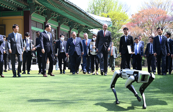 Spot, a four-legged robot, leads the way for the Bureau International des Expositions delegation, during the lunch event with SK Group Chairman Chey Tae-won in central Seoul, Monday. [JOINT PRESS CORPS]