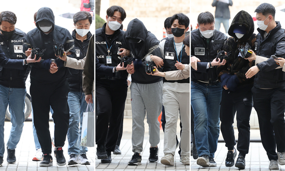 Three men accused of kidnapping and murdering a woman in her 40s in Gangnam District, southern Seoul, are escorted to the Seoul Central District Court in Seocho District on Monday morning to attend their arrest warrant reviews. They are also accused of dumping the victim's body near the Daecheong Dam in Daejeon. [YONHAP] 