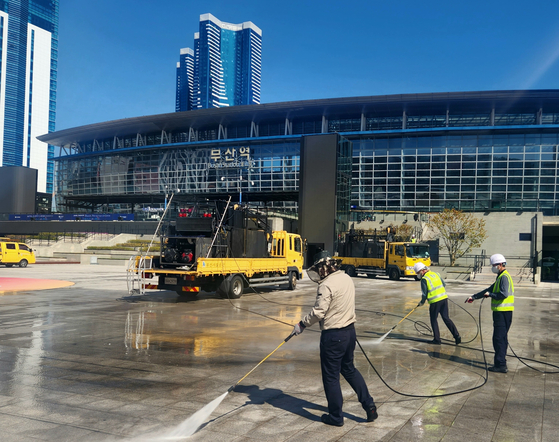 People clean up a square in front of Busan station ahead of BIE delegation's visit to the city on April 4. [YONHAP]