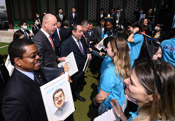 Supporters of Busan's bid to host the 2030 World Expo on Monday present caricatures of the Bureau International des Expositions (BIE) delegates as gifts at Hotel Shilla in Seoul after the delegation arrived for its week-long inspection to assess Busan's candidacy. Second from left is Patrick Specht, president of the BIE Administration and Budget Committee. [NEWS1]