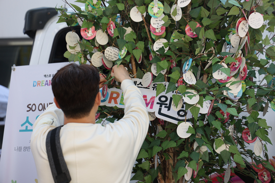 A citizen puts up a written message wishing for Busan's successful bid to host the World Expo 2030 in a promotional event organized by the Expo Dream Expedition in Jung District, Daejeon, Sunday [BUSAN METROPOLITAN CITY GOVERNMENT]