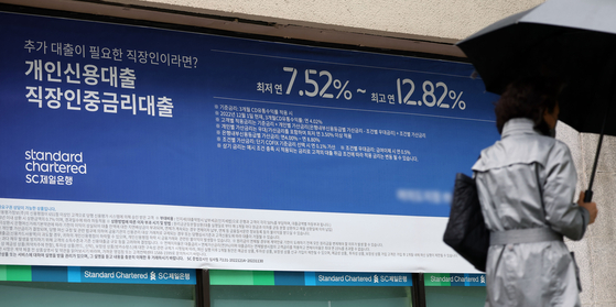 A passerby walks past a banner advertising loan programs in front of a bank in Seoul on Wednesday. The Financial Supervisory Service instructed banks to improve loan structures in consideration of households amid bank failures globally. The regulator aims to have fixed-rate loans account for 52 percent of all household loans this year. [YONHAP]