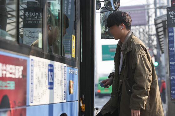 A person gets on a bus without a mask on March 20, the first day the public transportation mask mandate was lifted. [YONHAP] 
