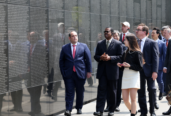 A Bureau International des Expositions (BIE) mission takes a look at the Wall of Remembrance, which lists 40,896 names of the United Nations forces who died in the Korean War, during a tour at the United Nations Memorial Cemetery in Korea on Thursday. [YONHAP]