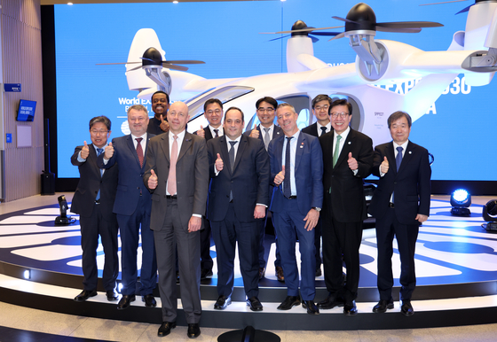 A Bureau International des Expositions delegation and Busan Mayor Park Heong-joon pose with an urban air mobility (UAM) vehicle after having a virtual tour of the North Port on Wednesday at the Busan Port International Exhibition & Convention Center. [YONHAP]