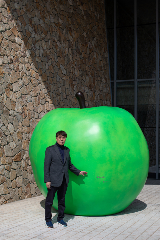 Tadao Ando stands in front of his green apple installation "Youth" (2023) at Museum SAN in Gangwon. [MUSEUM SAN]