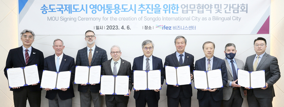 Incheon Free Economic Zone (IFEZ) Commissioner Kim Jin-yong, center, poses for a photo during a signing ceremony at G Tower in Songdo on Thursday. The memorandum of understanding signed on the same day aims to turn Songdo International City into a bilingual city. IFEZ plans to shape the region as a bilingual zone to host foreign investment and improve living conditions for foreigners. [INCHEON FREE ECONOMIC ZONE]
