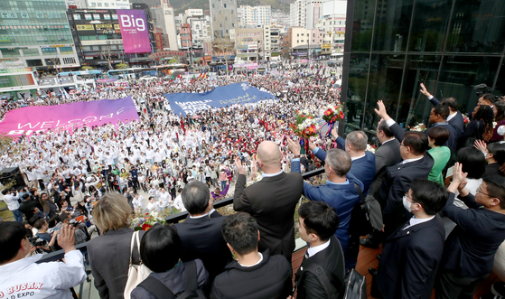 The Bureau International des Expositions delegation waves to about 5,500 Busan residents who showed up at Busan Station to greet the inspection team on Tuesday. [YONHAP]