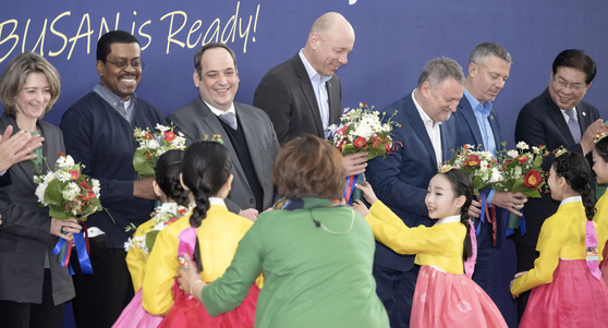 Children on hanbok, or traditional Korean dress, deliver welcoming flowers to the BIE inspection team at Busan Station on Tuesday. [YONHAP]