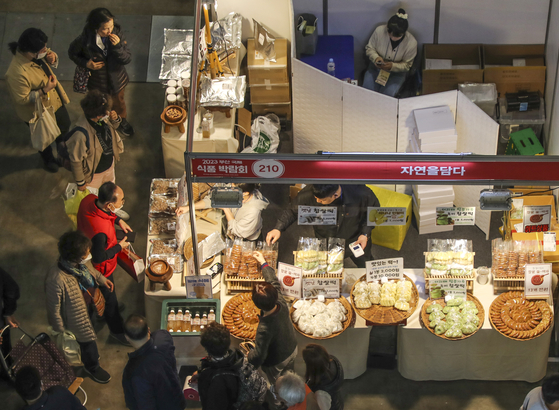 Visitors to the Busan International Food Expo 2023 take a look around different booths on March 9 at the Bexco in Busan's Haeundae District. The event has been organized to offer a variety of tasty treats from around the world available in Busan. [YONHAP] 