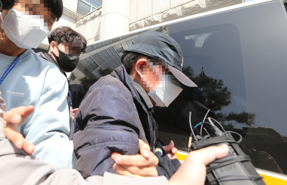 The drunk driver that killed a 9 year-old being escorted by the police on Monday in Daejeon to a district court where his arrest warrant will be reviewed by a judge. [YONHAP]