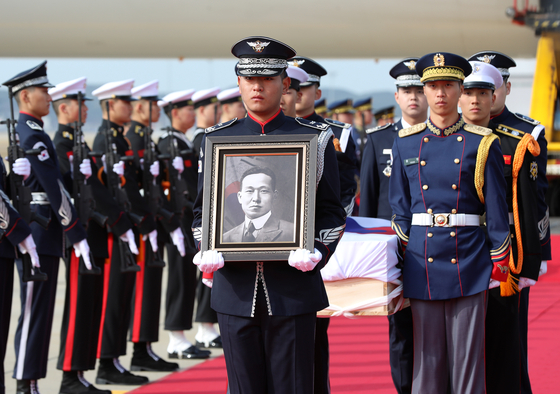 A military honor guard escorts the casket containing the remains of Whang Ki-hwan. The guard at the head of process is carrying his portrait. [JOINT PRESS CORPS]