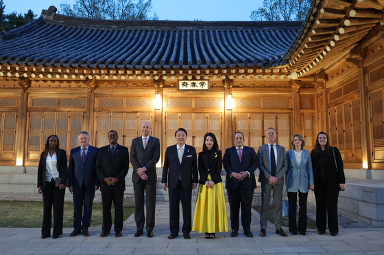 President Yoon Suk Yeol, center left, and first lady Kim Keon-hee, center right, pose for a commemorative photo with a visiting delegation of the Bureau International des Expositions (BIE) overseeing Busan's World Expo 2030 bid at a banquet at the Blue House Sangchunjae in central Seoul Monday. [PRESIDENTIAL OFFICE]