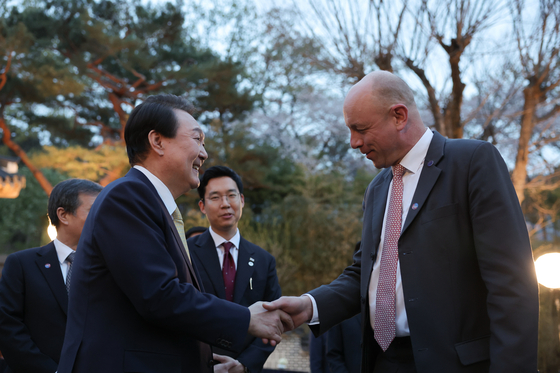 President Yoon Suk Yeol, left, greets Patrick Specht, president of the BIE's Administration and Budget Committee, at the Sangchunjae in the Blue House compound in central Seoul on Monday. [PRESIDENTIAL OFFICE]