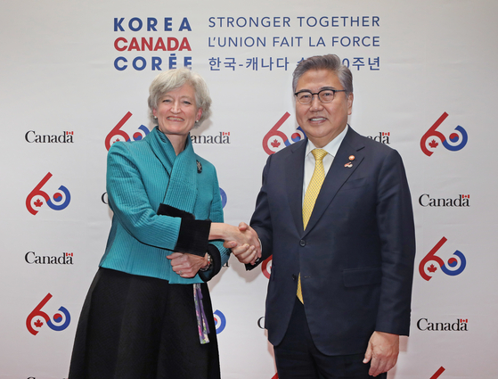 Tamara Mawhinney, chargee d'affaires of Canada to Korea, left, celebrates the 60th annivesary of Canada-Korea relations with Foreign Minister Park Jin at the Canadian Embassy in Seoul on Jan. 12. [PARK SANG-MOON]