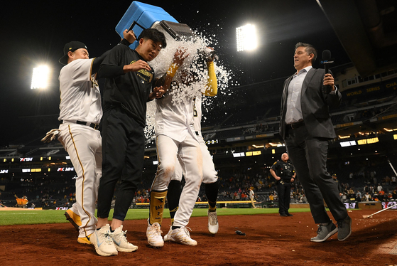 Choi Ji-man, left, and Jack Suwinski, right, douse Bae Ji-hwan, center, after Bae hit a walk-off three-run home run for a 7-4 win over the Houston Astros at PNC Park in Pittsburgh on Tuesday.  [AFP/YONHAP]