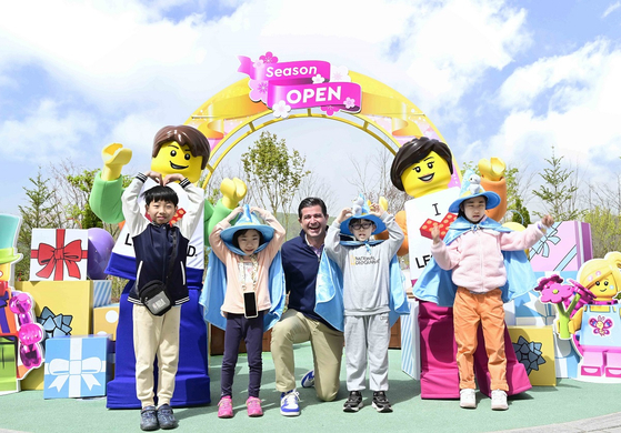 CEO of Legoland's operator Merlin Entertainment Scott O'Neil, center, poses for a photo with children adorned in wizard capes and hats who were invited to the theme park Wednesday as part of Merlin's social contribution event ″Merlin's Magic Wand.″ Legoland Korea invited families of people with disabilities living in Chuncheon to the amusement park on this day and plans on bringing 300 more next week in line with Korea's Day of Disabled People on April 20. Merlin Entertainment, a major European theme park company that also operates COEX in Seoul and Sealife Aquarium in Busan, has hosted more than 800,000 children from underprivileged families at its social contribution events. [LEGOLAND KOREA]