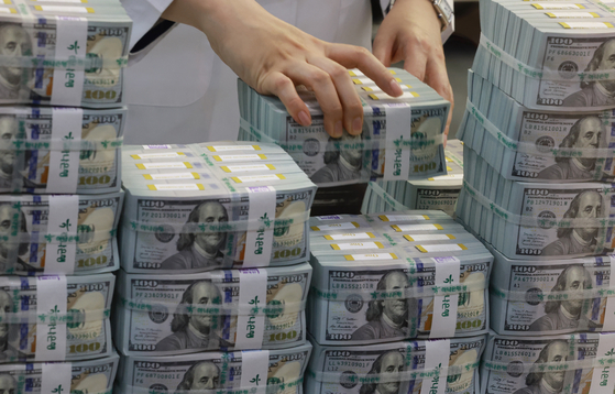 An employee organizes dollars at Hana Bank in central Seoul on April 5. [YONHAP]