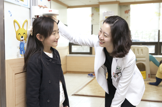 A pediatrician at Konyang University hospital in Daejeon measures the height of a 9-year-old girl surnamed Jeong. [JOONGANG ILBO]
