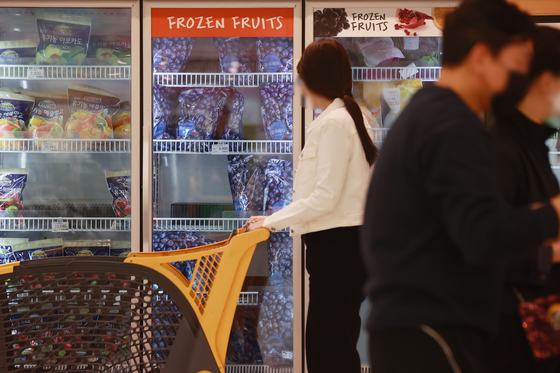 Customers shop for frozen fruits at a discount mart in downtown Seoul on Sunday. With prices of fruits and vegetables rising constantly, demand for cheaper frozen options is on the rise. Sales of frozen vegetables at Emart rose by 22.4 percent between April last year and the end of March this year. [YONHAP]