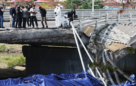 Officials from the forensic service and the police inspects the Jeongja bridge in Bundang that collapsed on April 5 few days later it happened. The government on Monday announced that it will conduct a nationwide safety inspections on such infrastructures until mid June. [YONHAP]