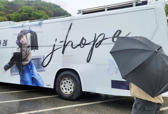 A bus wrapped with an advertisement to support J-Hope of boy band BTS as he starts his two-year military duty on Tuesday is parked outside the basic training camp in Wonju, Gangwon. Only a few fans and reporters were present at the scene and J-Hope did not stop to bid farewell. [YONHAP]