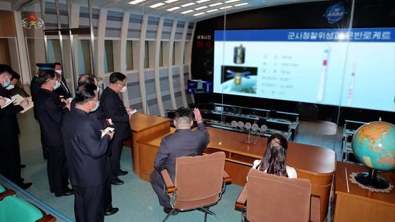 Footage released by the North's state-controlled Korean Central Television shows leader Kim Jong-un pointing toward a screen display of the regime's planned reconnaissance satellite. [YONHAP]