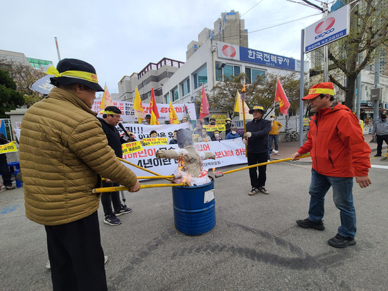 The refugees of the Goseong wildfire that happened in 2019 burning a doll that suppose to Kepco in front of the power company’s Seokcho branch office on April 4 in marking the fourth anniversary of the fire. [YONHAP]