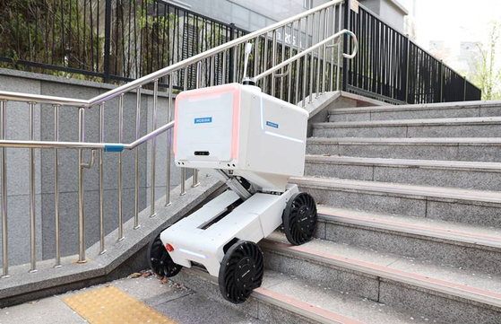 Self-driving robot start-up Mobinn's delivery robot climbs stairs at an apartment complex in Gwanggyo, Gyeonggi. [CU]