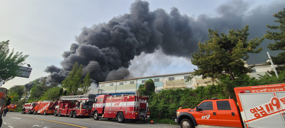 Fire trucks are parked on a road next to Hankuk Carbon factories in Miryang, South Gyeongsang, on Friday. [YONHAP]