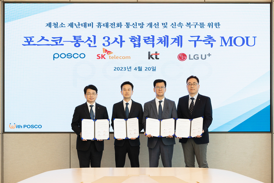 Officials, including Shim Min-seok, head of Posco's digital innovation office, far left, pose for a photo after signing an MoU to improve and expedite communication networks for disaster response at Posco's steel mills, at the Posco Center in southern Seoul on Thursday. [POSCO]