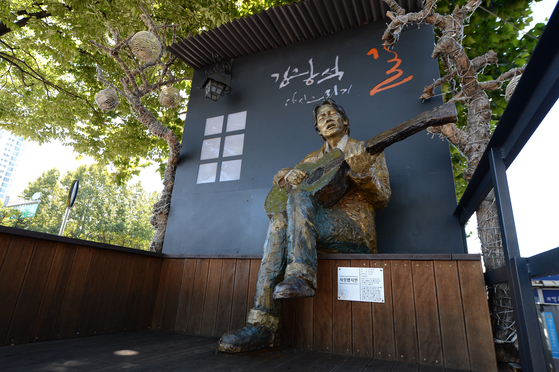 한국의 현대 포크 가수 김광석의 동상은 방문객들에게 추억의 사진을 찍을 수 있는 장소를 제공합니다. [DAEGU CITY]