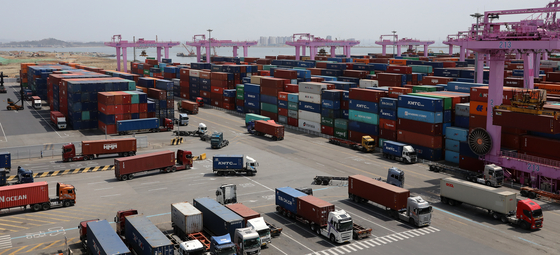 Trucks transport containers at a port in Incheon on April 14. [NEWS1]
