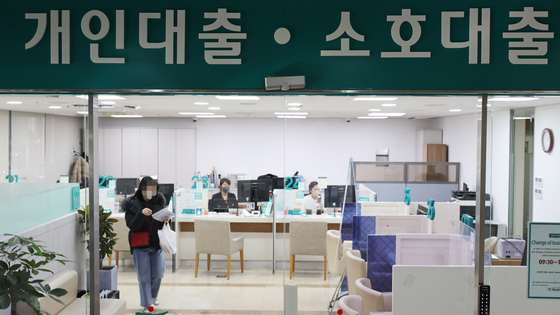 Customers conduct banking at a bank counter in Seoul in January. [YONHAP] 