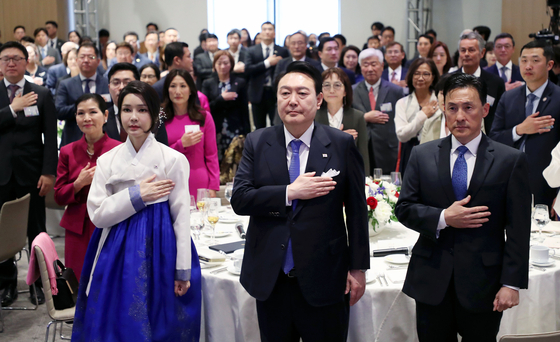 President Yoon Suk Yeol, center, and first lady Kim Keon-hee, left, take part in a dinner banquet with Korean compatriots at a hotel in Washington on Monday evening. [JOINT PRESS CORPS]