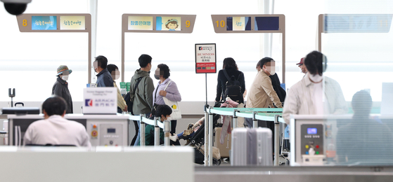 Travelers visit a tour company booth at Incheon International Airport on Monday. [YONHAP]
