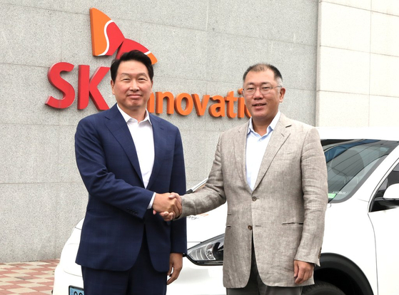 SK Group Chairman Chey Tae-won, left, shakes hands with Hyundai Motor Group Executive Chair Euisun Chung at SK On's Seosan factory in South Chungcheong in July 2020. [SK ON]