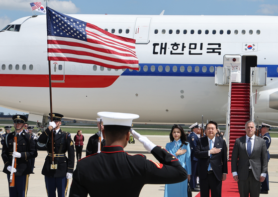 A U.S. honor guard salutes President Yoon Suk Yeol and first lady Kim Keon-hee after their arrival at the Andrews Air Force Base in Maryland on Monday. [JOINT PRESS CORPS]