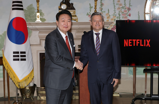President Yoon Suk Yeol, left, shakes hands with Netflix co-CEO Ted Sarandos in a meeting at Blair House in Washington on Monday. [JOINT PRESS CORPS]