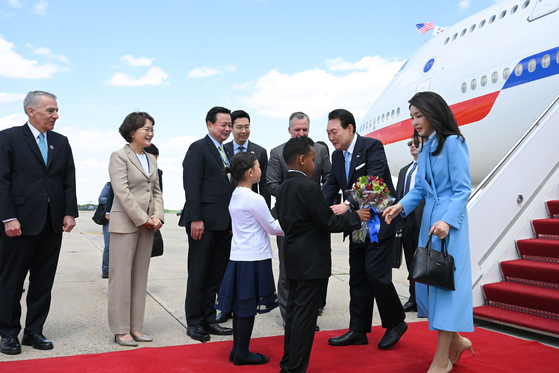 President Yoon Suk Yeol, left, and first lady Kim Keon-hee are greeted by children as they arrive at Joint Base Andrews in Maryland on Monday afternoon to kick off a weeklong state visit to the United States. [JOINT PRESS CORPS]