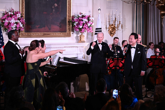 U.S. President Joe Biden, center, and Broadway stars react as President Yoon Suk Yeol, right, sings ″American Pie″ by Don Mclean during the state dinner at the White House in Washington, Wednesday. [AP/YONHAP]