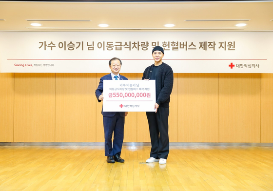 Lee Seung-gi, right, donates 550 million won ($450,000) to the Korean Red Cross. Pictured left is Shin Hee-young, president of the Korean Red Cross. [KOREAN RED CROSS]