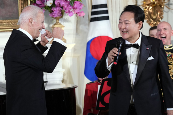 U.S. President Joe Biden, left, reacts as President Yoon Suk Yeol sings ″American Pie″ by Don Mclean during the state dinner at the White House in Washington, Wednesday. [AP/YONHAP]