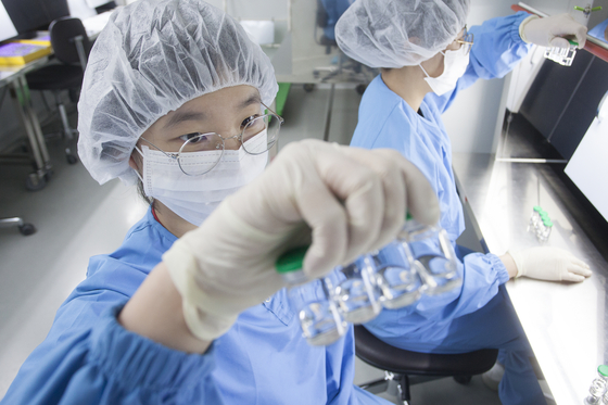 SK bioscience researchers check SKYCovione Covid-19 vaccine vials at L House, the company’s vaccine manufacturing facility in Andong, North Gyeongsang. [SK BIOSCIENCE] 