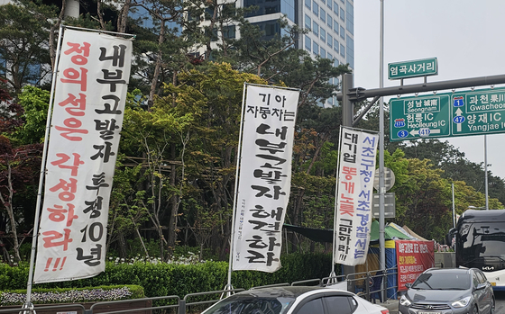 Standing banners and a tent are installed by a protester in front of Hyundai Motor's headquarters building in Seocho District, southern Seoul, on April 23. [SHIN HA-NEE]