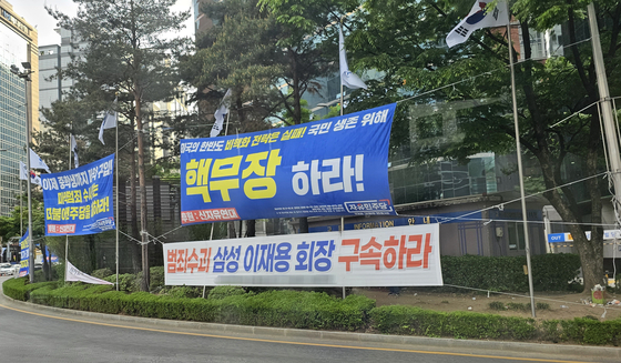 Banners are installed near the Gangnam Station in southern Seoul on April 24. The top banner reads "Nuclearize South Korea," and the bottom reads "Arrest Samsung's Lee Jae-yong, the crime ring leader." [SHIN HA-NEE]