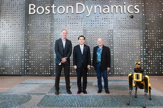 From left, Boston Dynamics Chief Legal Officer Jason Fiorillo, Industry Minister Lee Chang-yang and Boston Dynamics founder Marc Raibert pose for a photo in front of the company logo on Friday. [BOSTON DYNAMICS]