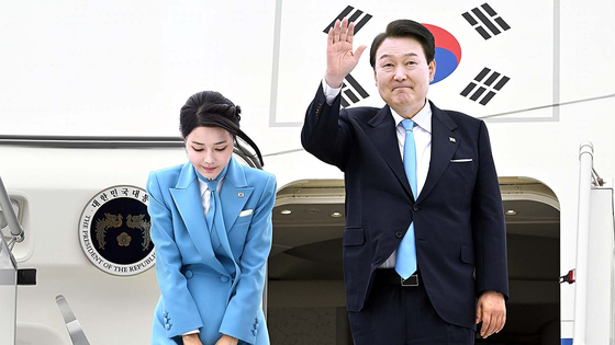 President Yoon Suk Yeol, right, waves alongside first lady Kim Keon-hee as they arrive in Korea on the presidential jet at Seoul Air Base in Gyeonggi, wrapping up a weeklong state visit to the United States on Sunday afternoon. [JOINT PRESS CORPS]