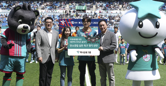 Hana Financial Group Vice Chairman Lee Eun-hyung, far left, and others hold a banner celebrating Daejeon Hana Citizen football team's commitment for carbon neutrality on Sunday. [Hana Financial Group]
