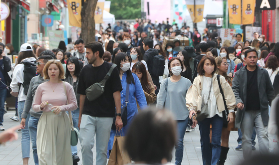 People roam the streets of Myeong-dong in Jung District, central Seoul, on Friday. [NEWS1]